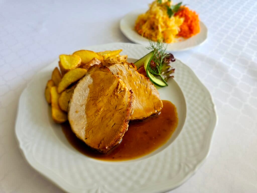 Urodziny i jubileusze w Restauracji Grand Felix — pieczeń z dodatkami podana na stole bankietowym